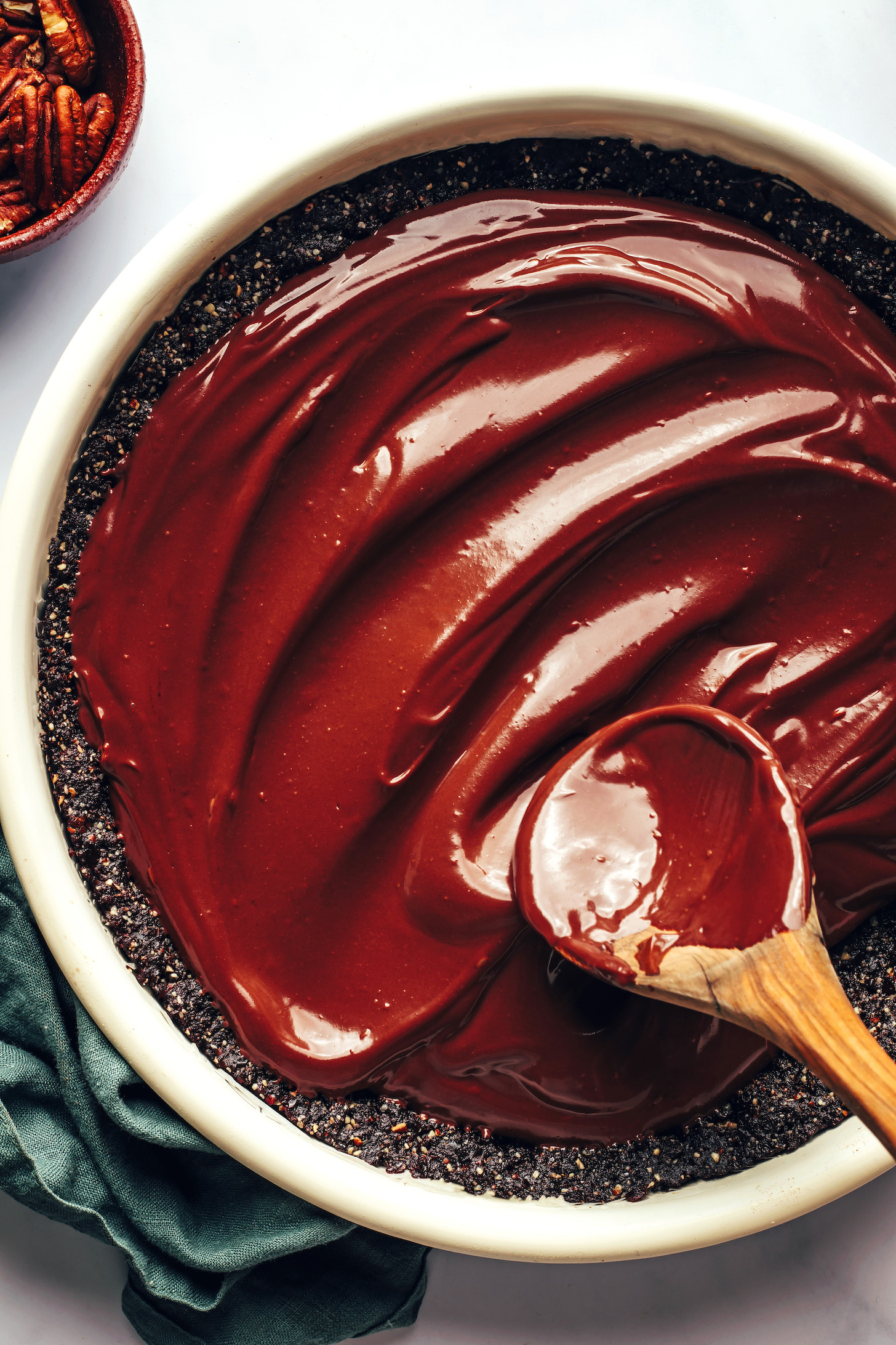 Spreading a thick ganache-like layer of chocolate filling into a pie crust
