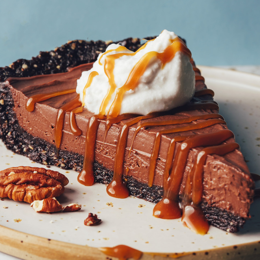 Slice of our easy chocolate mousse pie topped with coconut whipped cream and caramel sauce