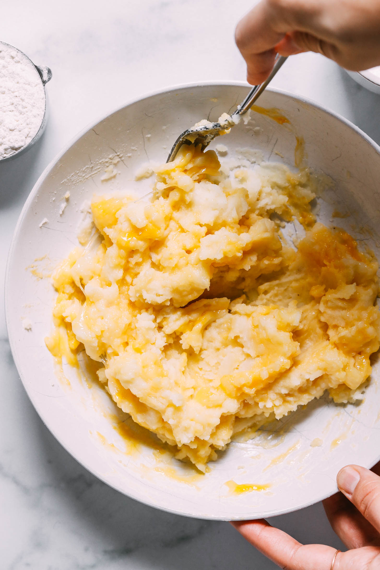 Mixing an egg into mashed potatoes 