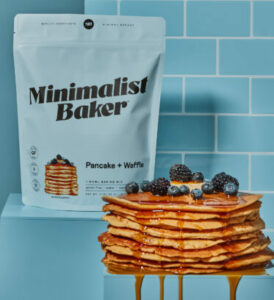 Bag of our gluten-free vegan pancake and waffles mix with a stack of pancakes in front of it