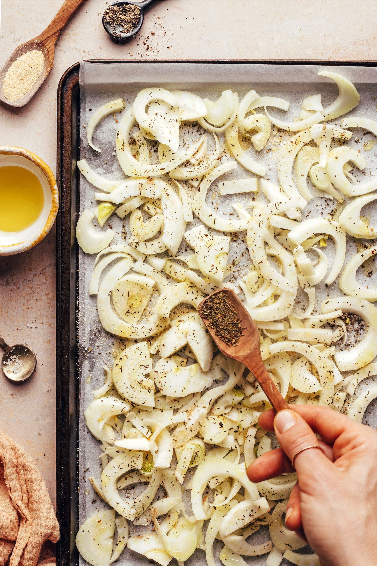 Sprinkling dried thyme over sliced fennel