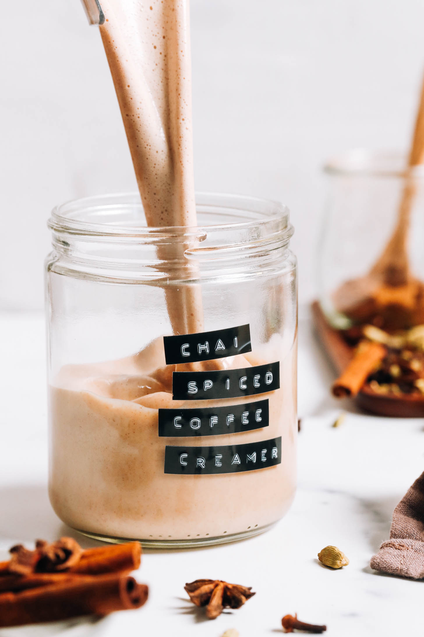 Verter crema de café con especias chai sin lácteos en un frasco de vidrio