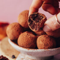 Holding a fudgy vegan chocolate truffle made with sweet potato