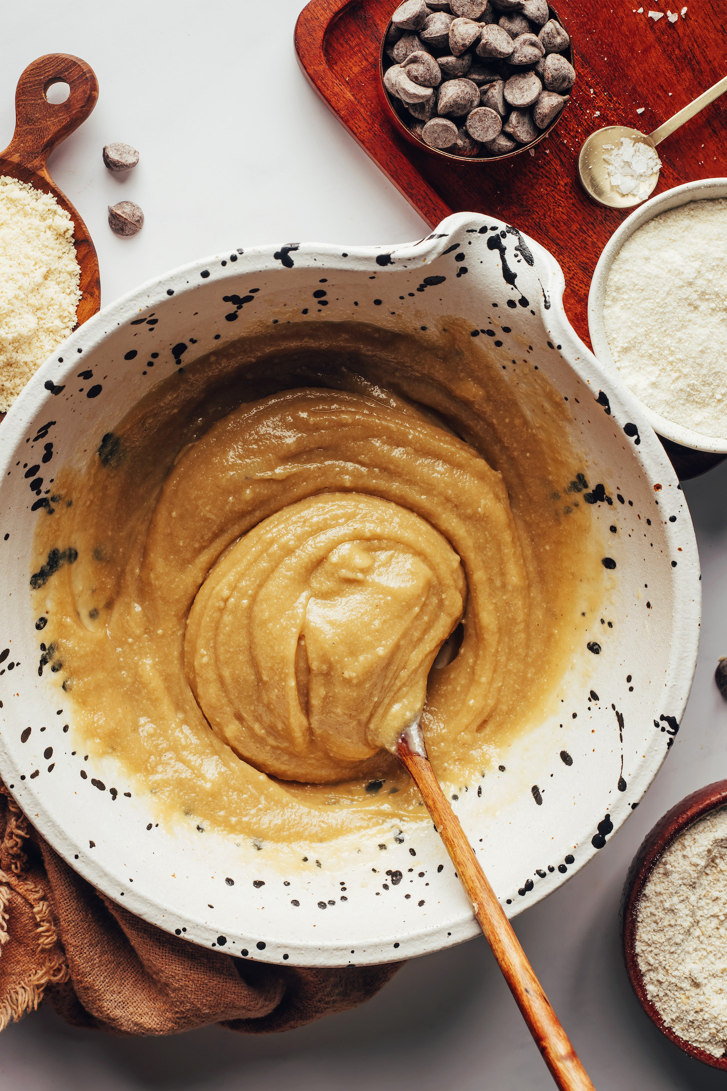 Stirring together cashew butter, maple syrup, and vanilla extract in a bowl