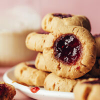 Stacks of vegan gluten-free peanut butter and jelly thumbprint cookies