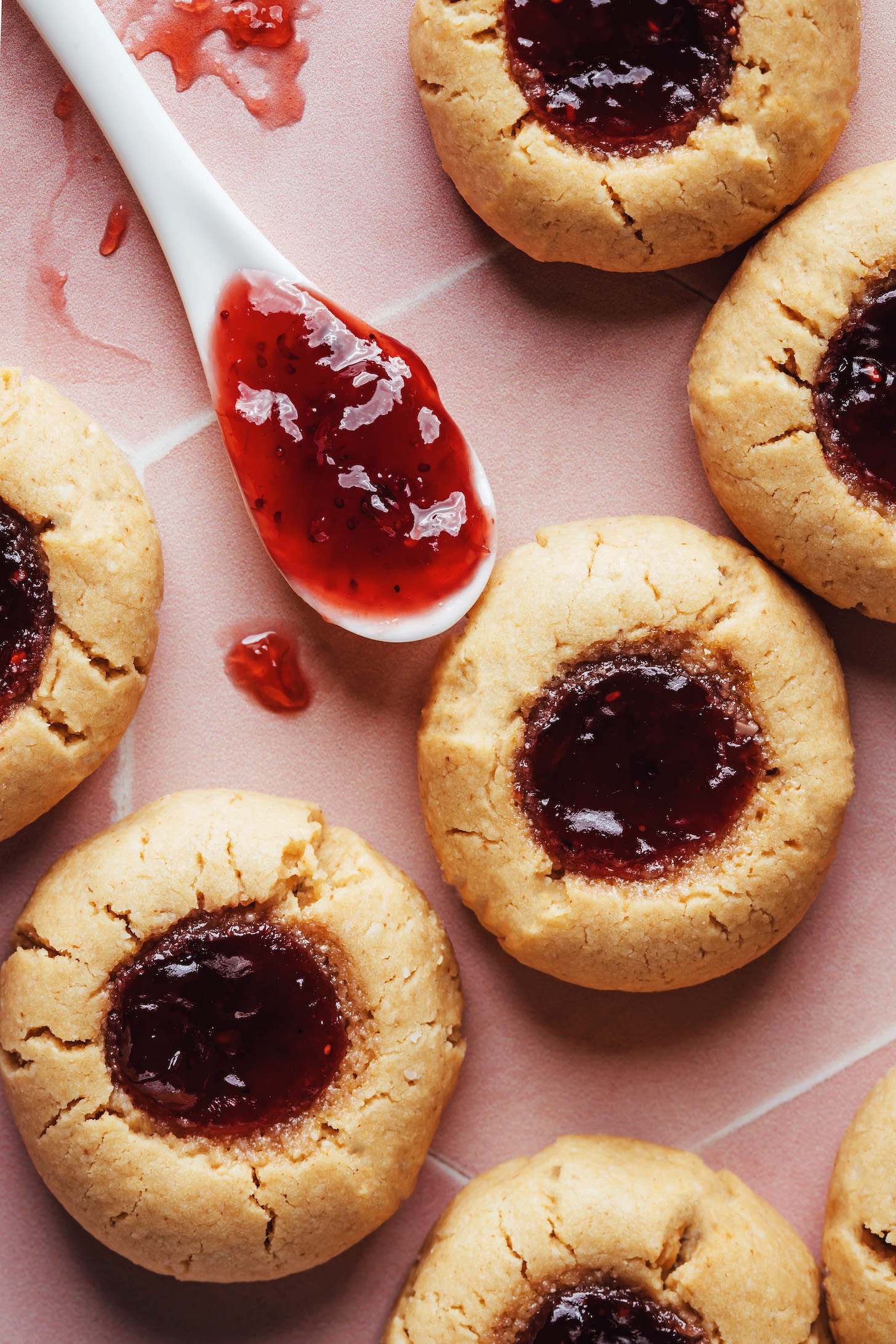 Close up shot of raspberry jam centers of peanut butter thumbprint cookies