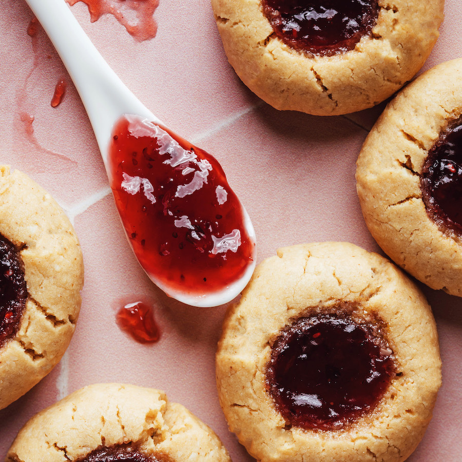 Close up shot of peanut butter thumbprint cookies filled with raspberry jam