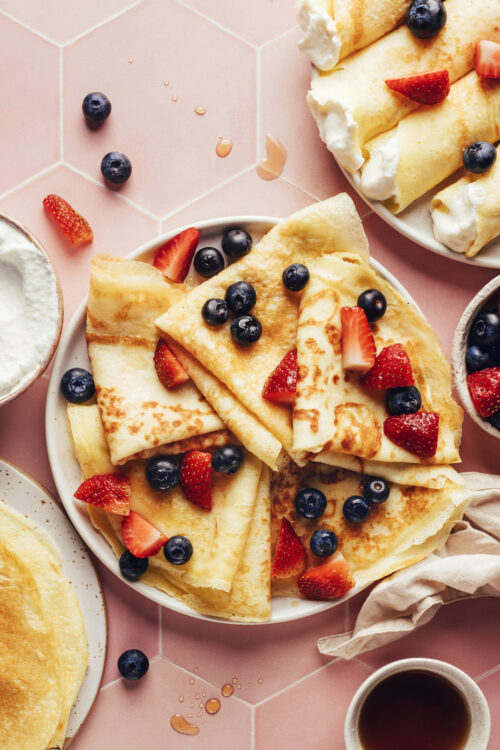 Plate of folded gluten-free crepes topped with fresh berries