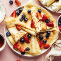 Plate of gluten-free dairy-free crepes topped with fresh berries