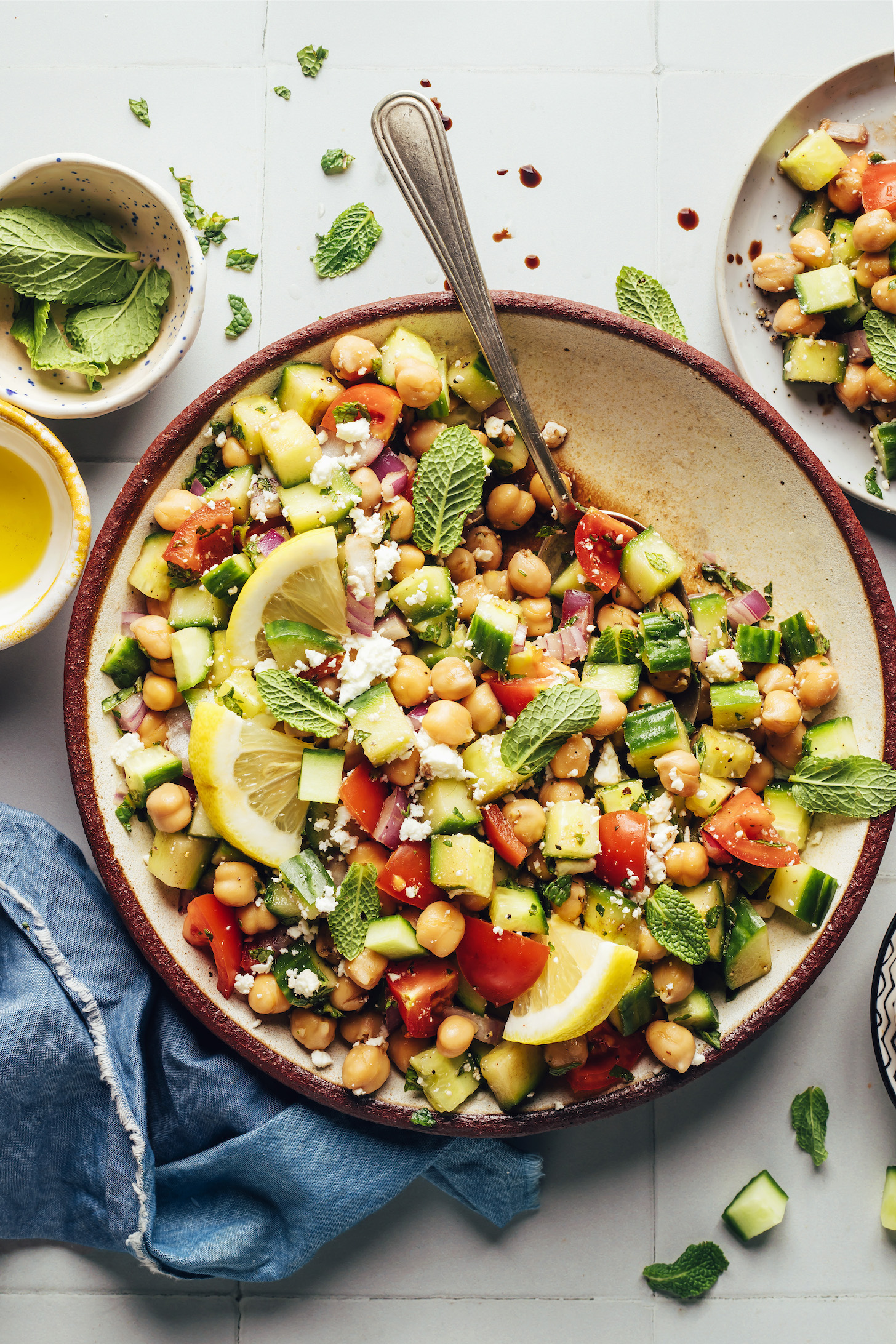 Spoon resting in a bowl of cucumber tomato chickpea salad