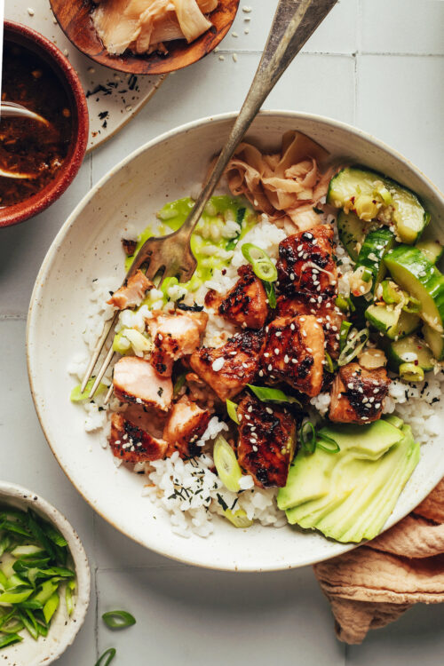 Salmon sushi bowl with cucumber salad, rice, and salmon