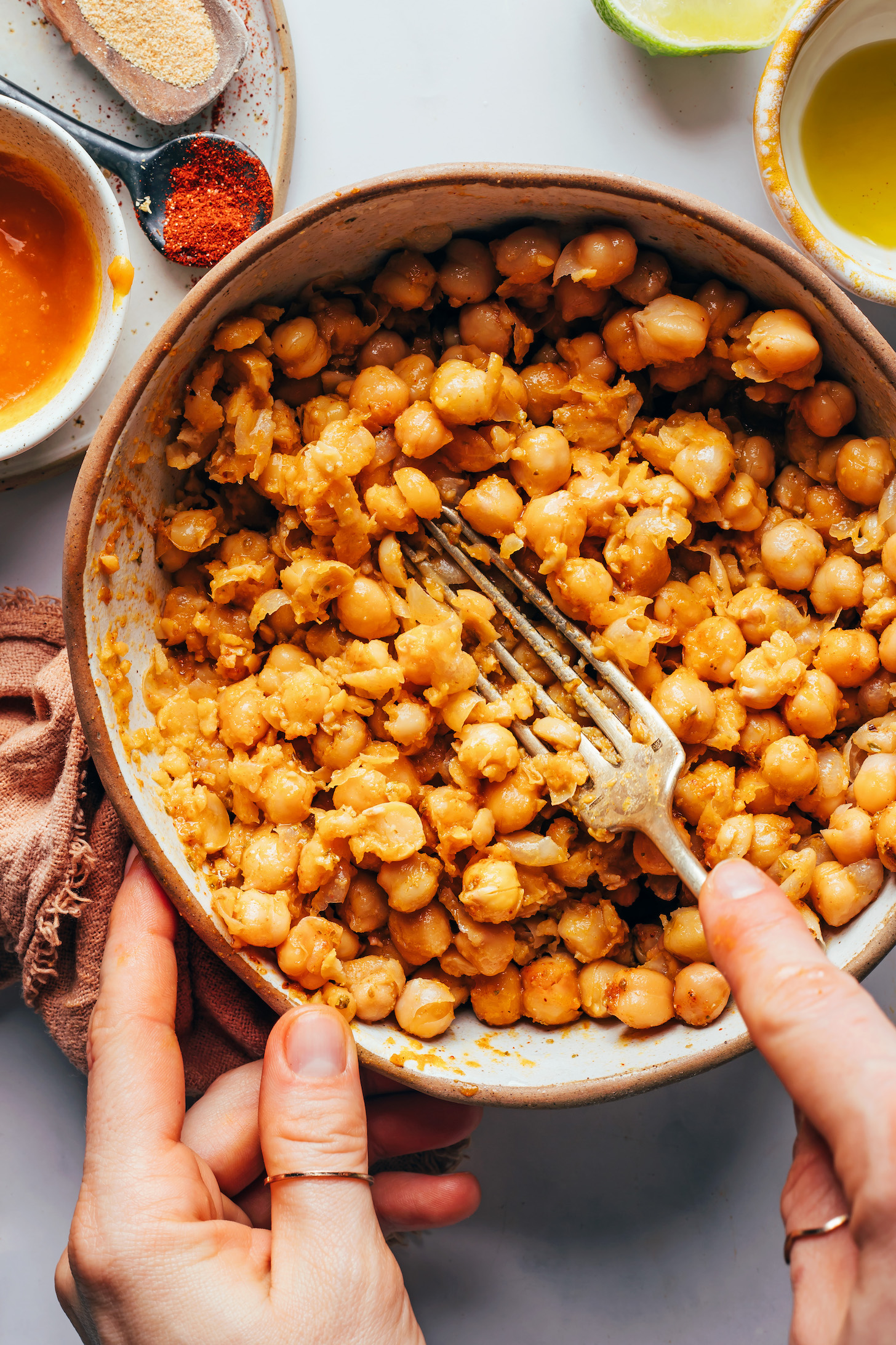 Using a fork to smash chickpeas in a bowl