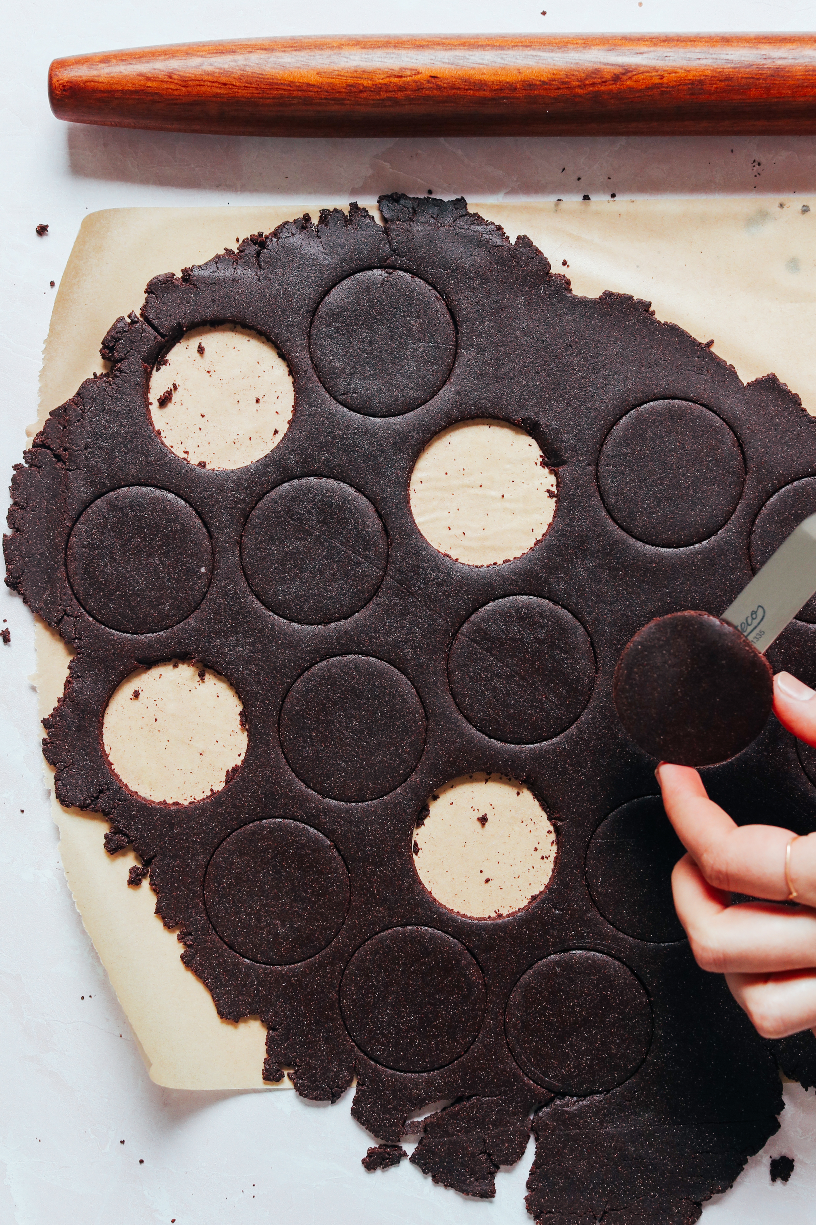 Masa de galleta de chocolate enrollada cortada con un cortador de galletas circular