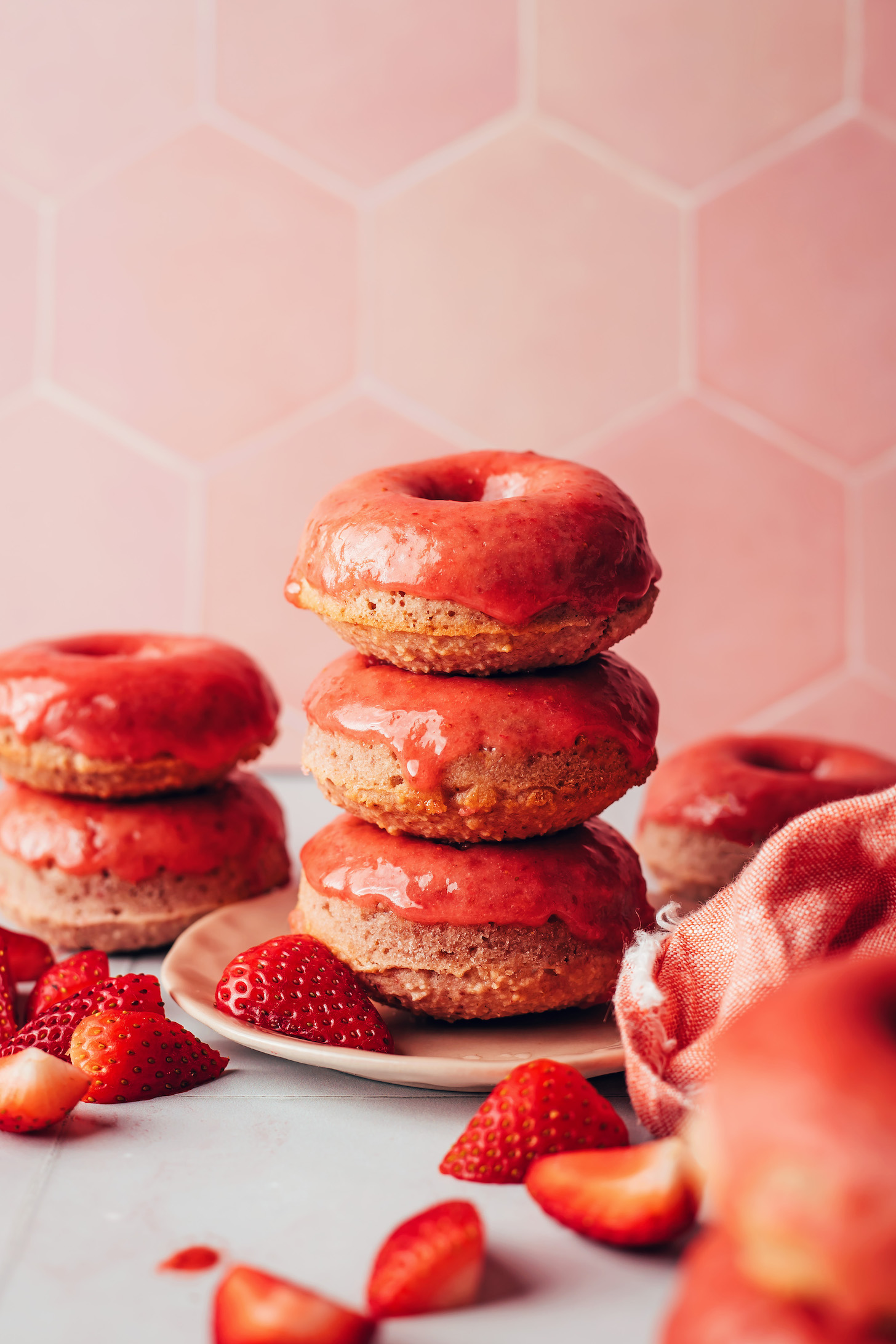 Stacks of vegan gluten-free strawberry donuts on a plate