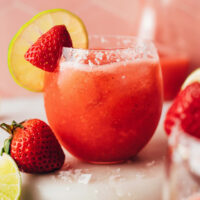 Glass filled with our fresh strawberry margarita recipe served over ice