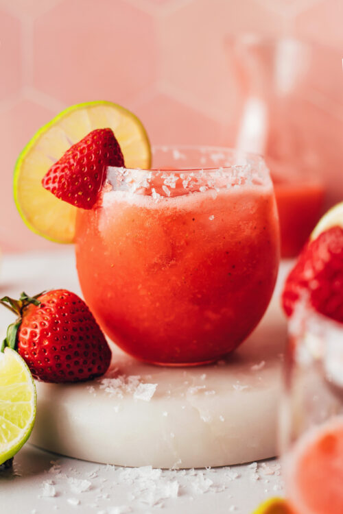 Glass filled with our fresh strawberry margarita recipe served over ice
