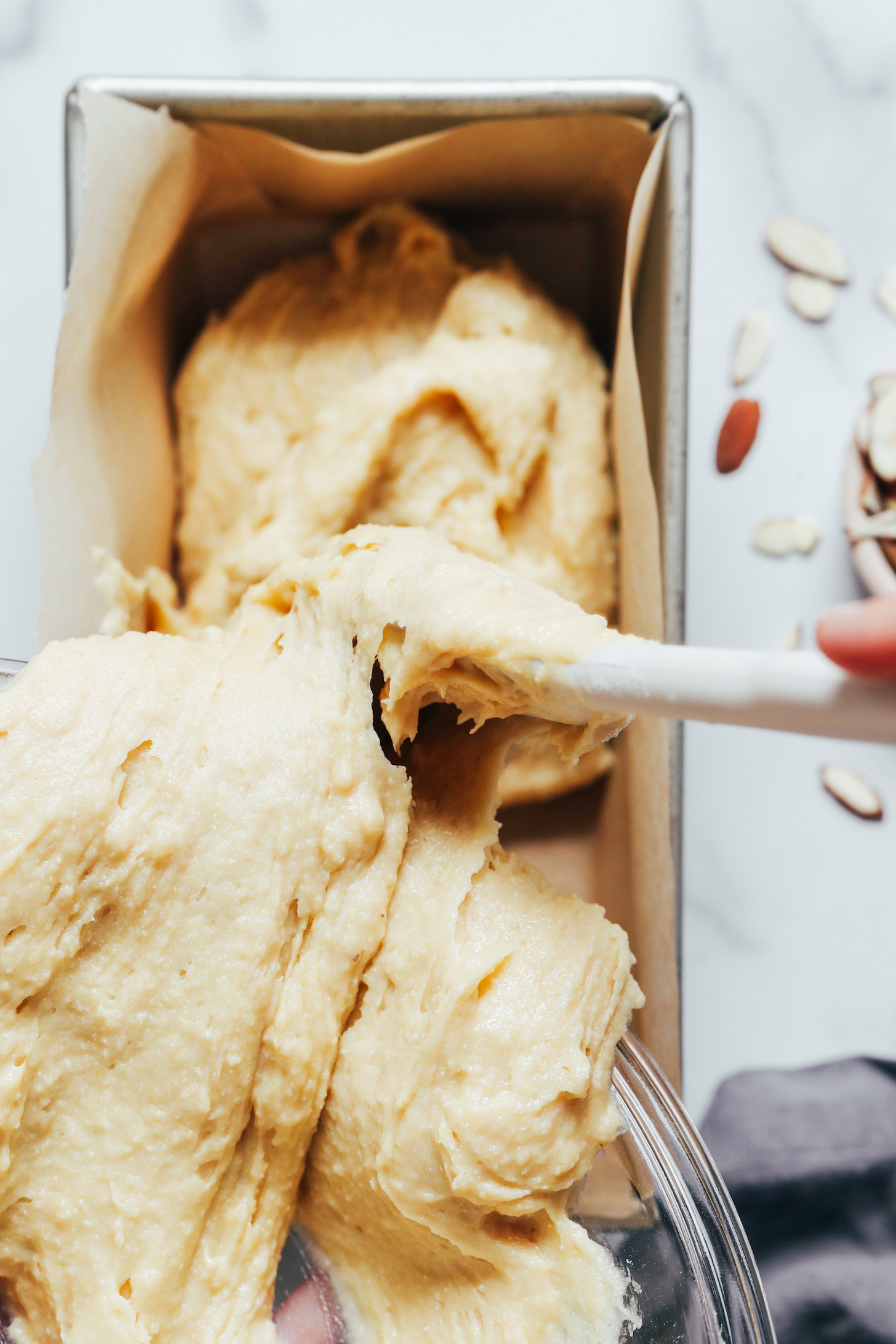 Transferring honey cake batter to a parchment-lined loaf pan