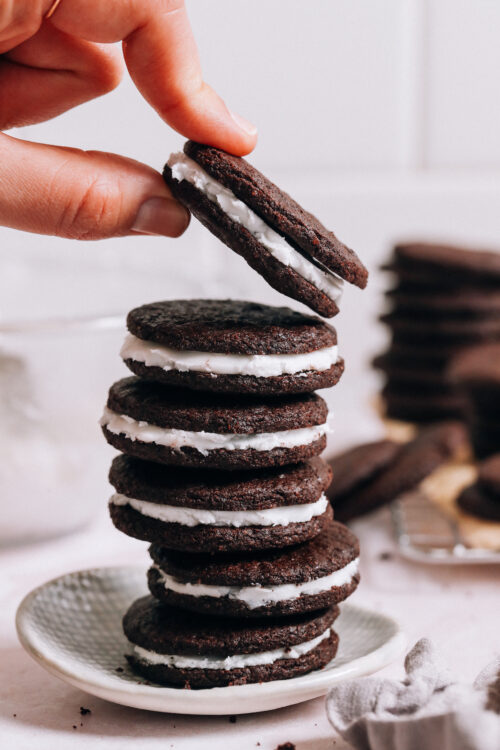 Picking up a homemade oreo from a stack of more cookies