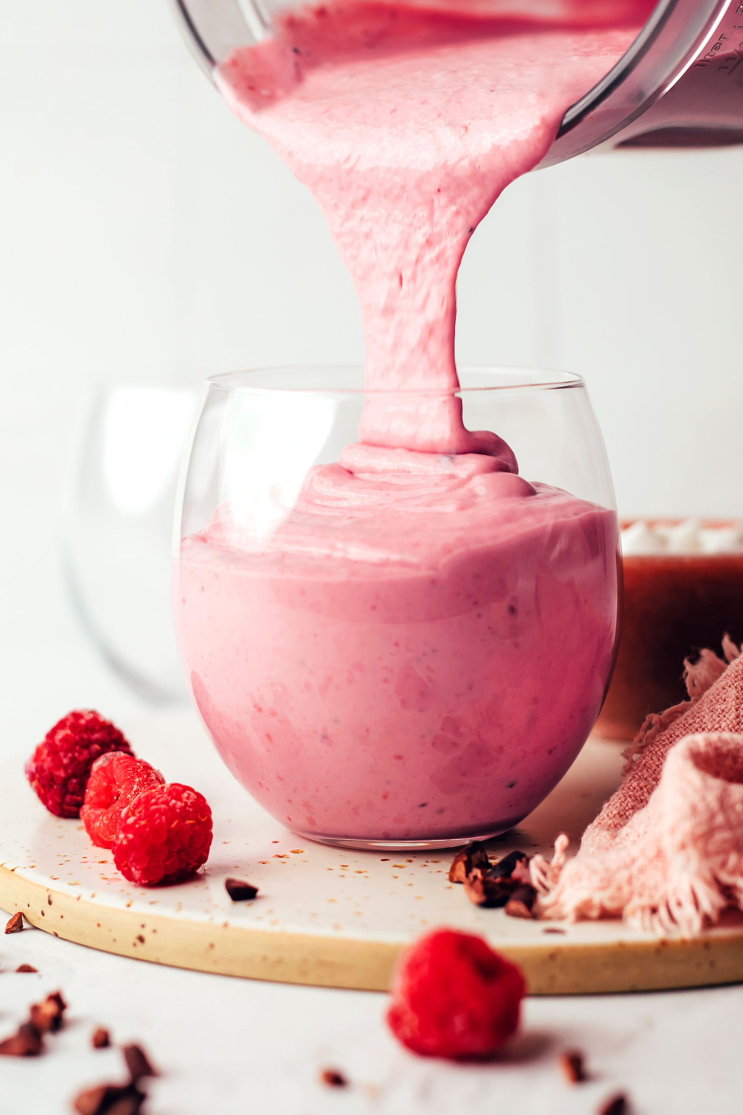 Pouring a raspberry chip smoothie from a blender into a glass