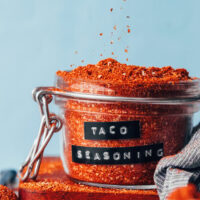 Sprinkling taco seasoning into a glass jar