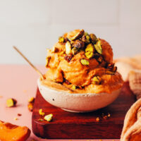 Bowl with scoops of apricot sorbet topped with candied pistachios