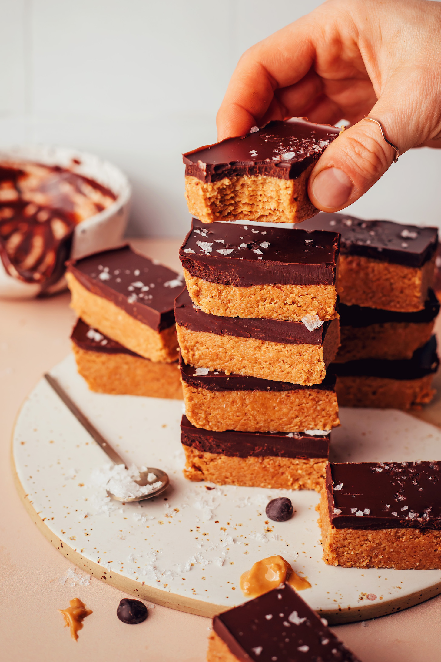 Holding a no-bake peanut butter cup bar above a stack of more bars
