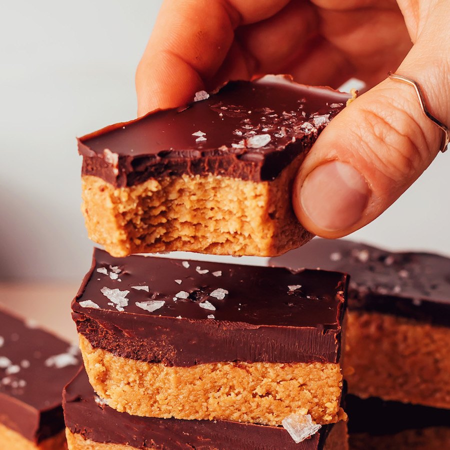 Holding a no-bake peanut butter cup bar topped with flaky salt