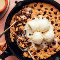 Scoops of vanilla ice cream on a tahini chocolate chip skillet cookie
