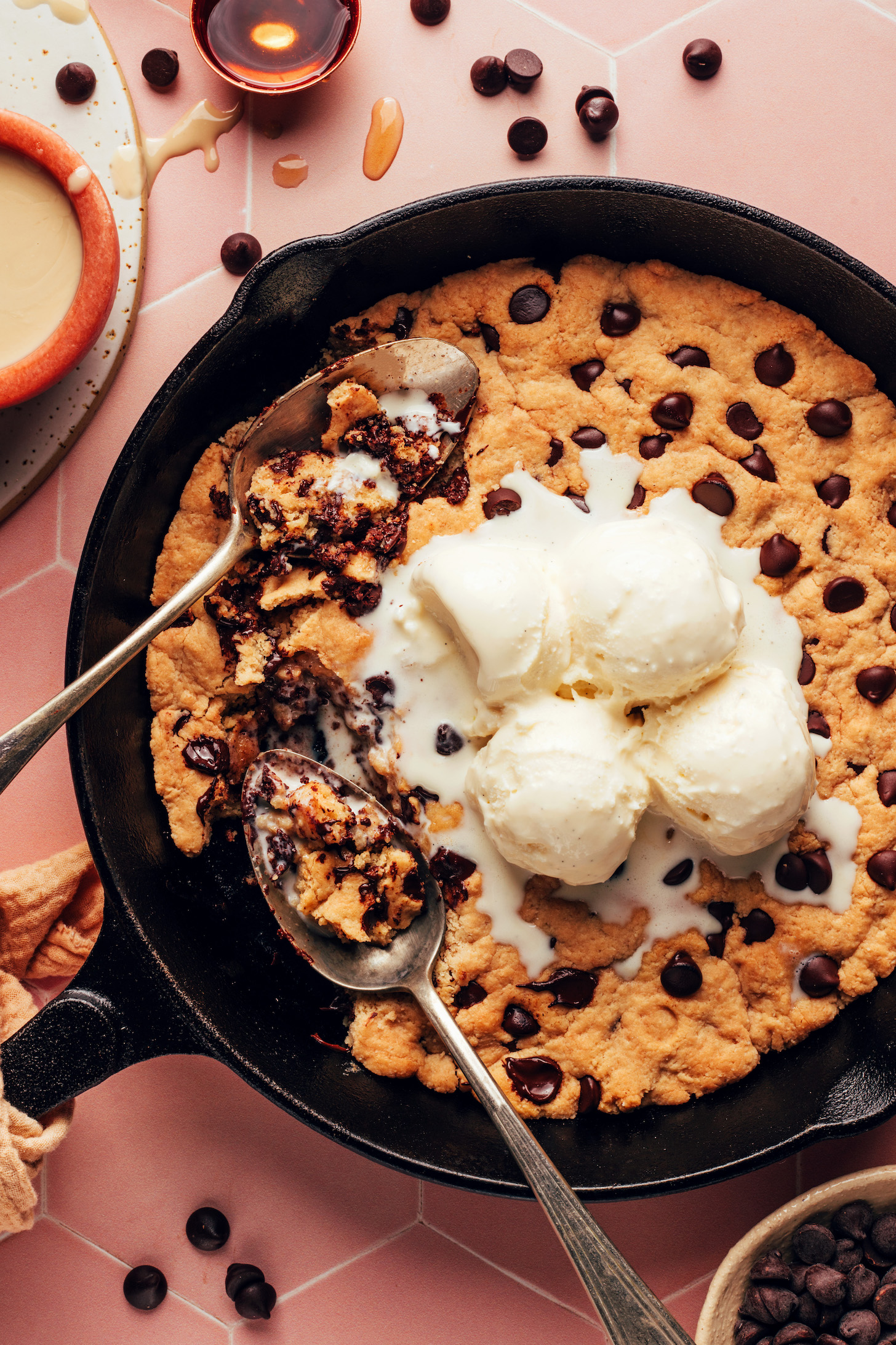Scoops of vanilla ice cream melting on top of a chocolate chip skillet cookie