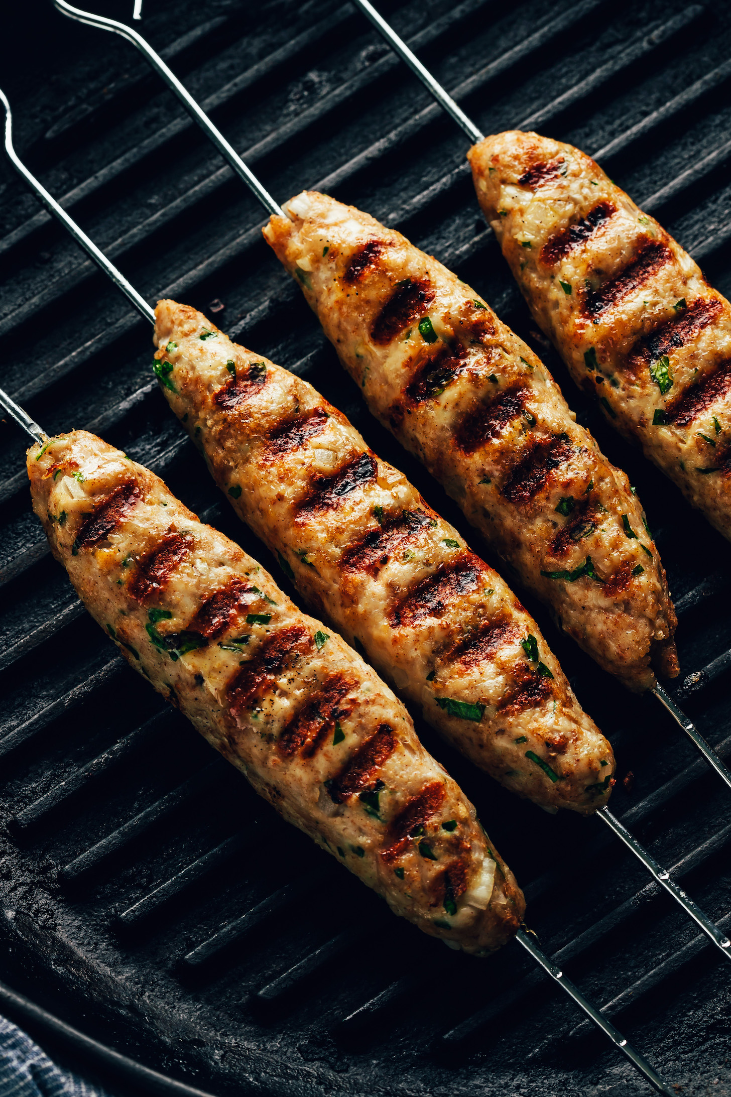 Chicken kofta kebabs on a grill pan with grill marks on one side of them