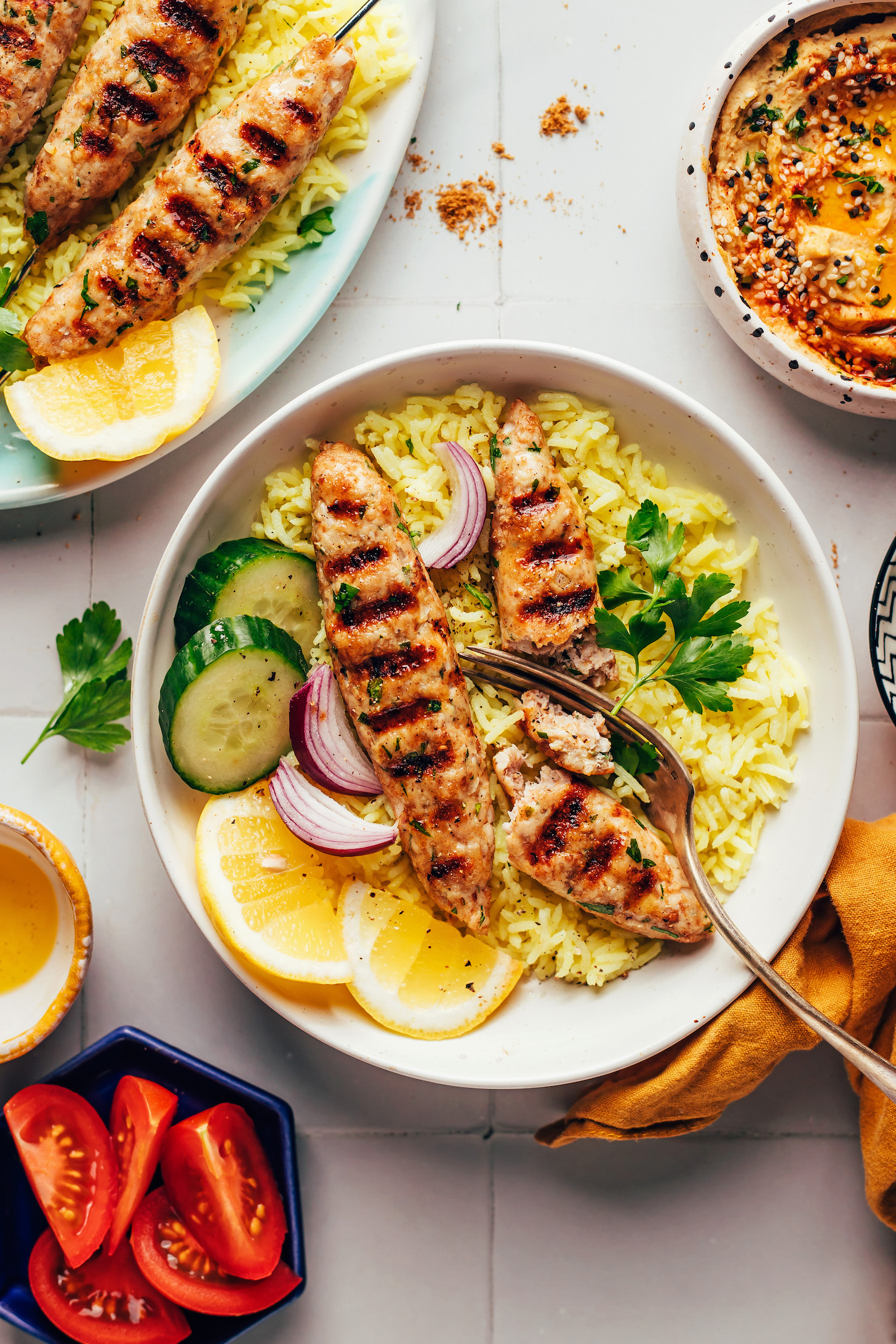 Chicken kofta kebabs cut open with a fork over a bowl of lemon rice