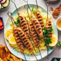 Grilled chicken kofta kebabs over a plate of lemon rice