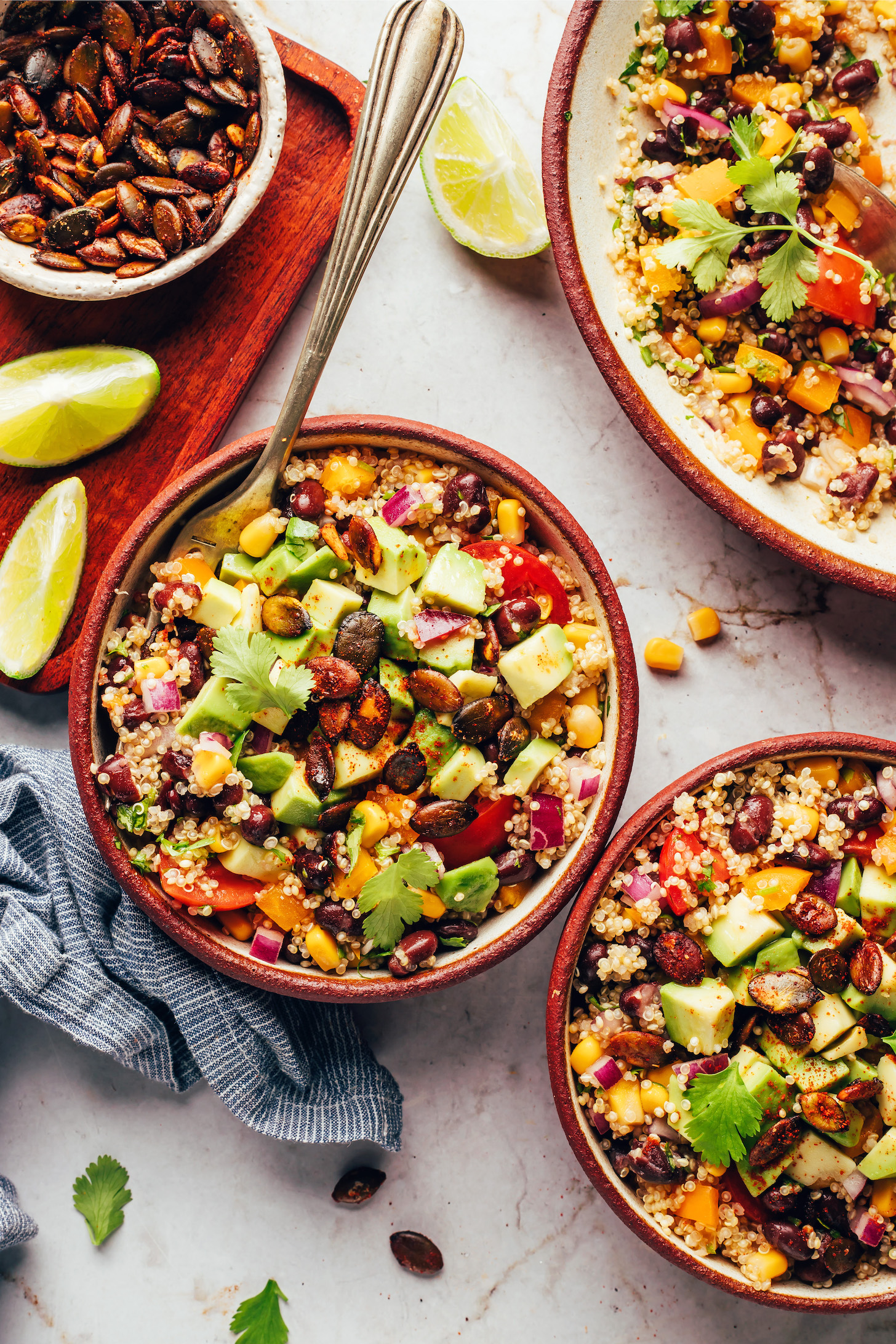 Bowls of our Southwest quinoa black bean salad topped with avocado and chili lime pepitas