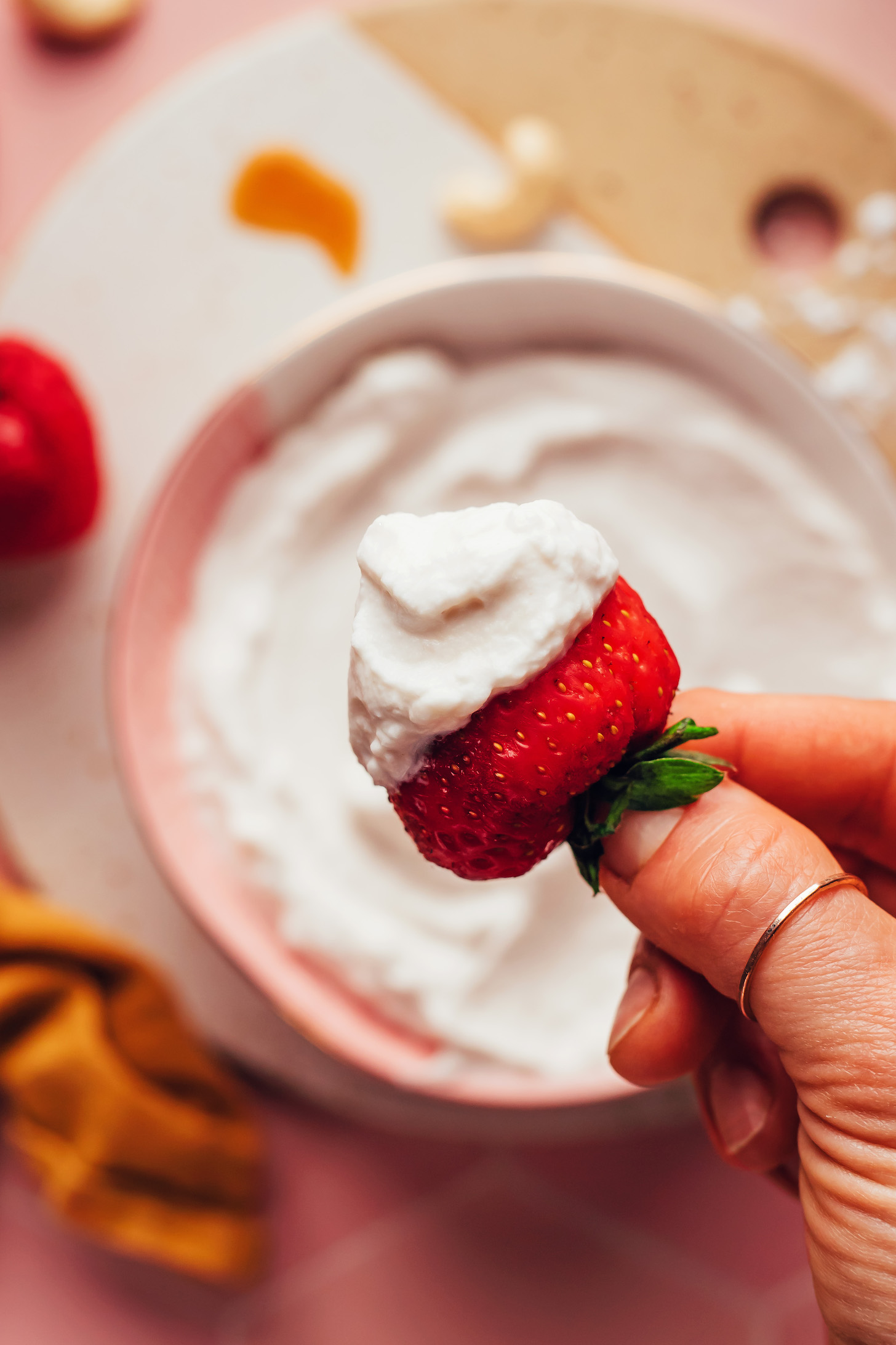 Vegan whipped cream on a fresh strawberry