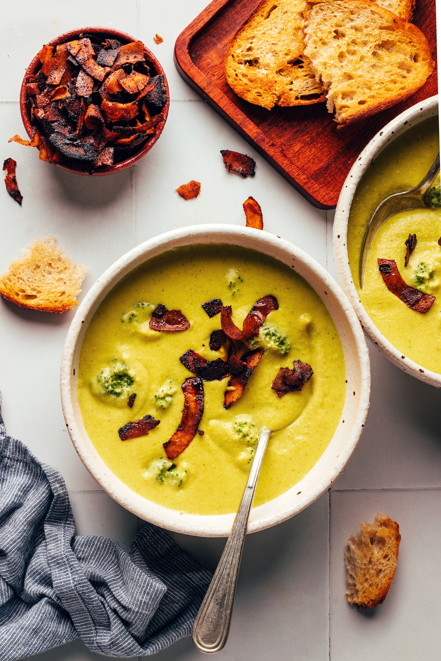 Bowls of broccoli cheddar soup topped with coconut bacon