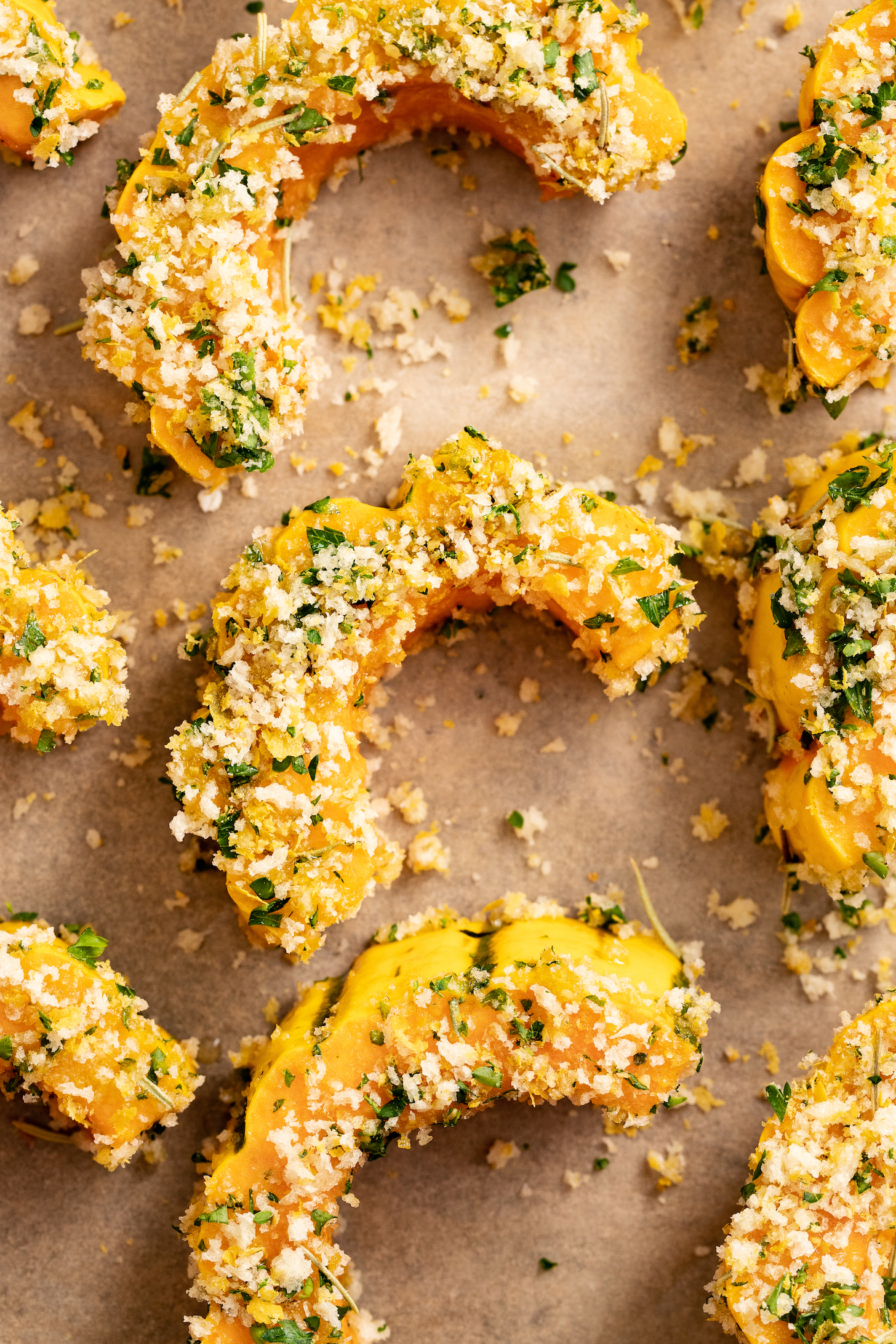 Close up photo of delicata squash with a garlic and herb breading before baking