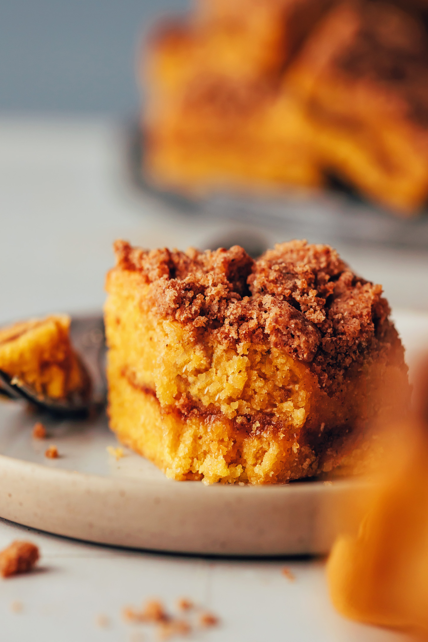Close up shot of a slice of pumpkin coffee cake with a bite removed