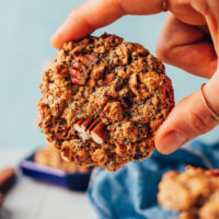 Holding a chai-spiced granola cookie with the top facing the camera