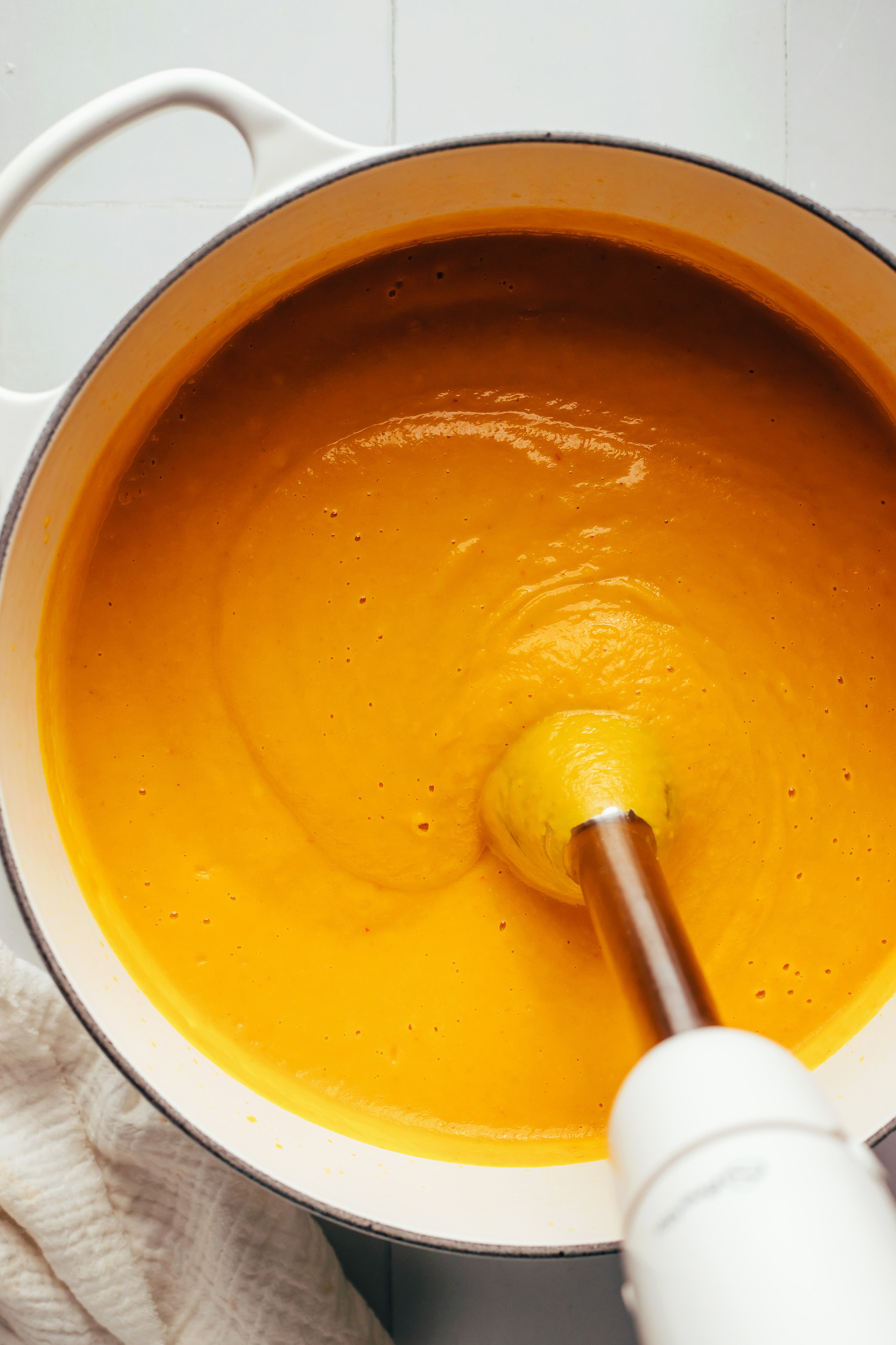 Using an immersion blender to purée a creamy carrot ginger soup