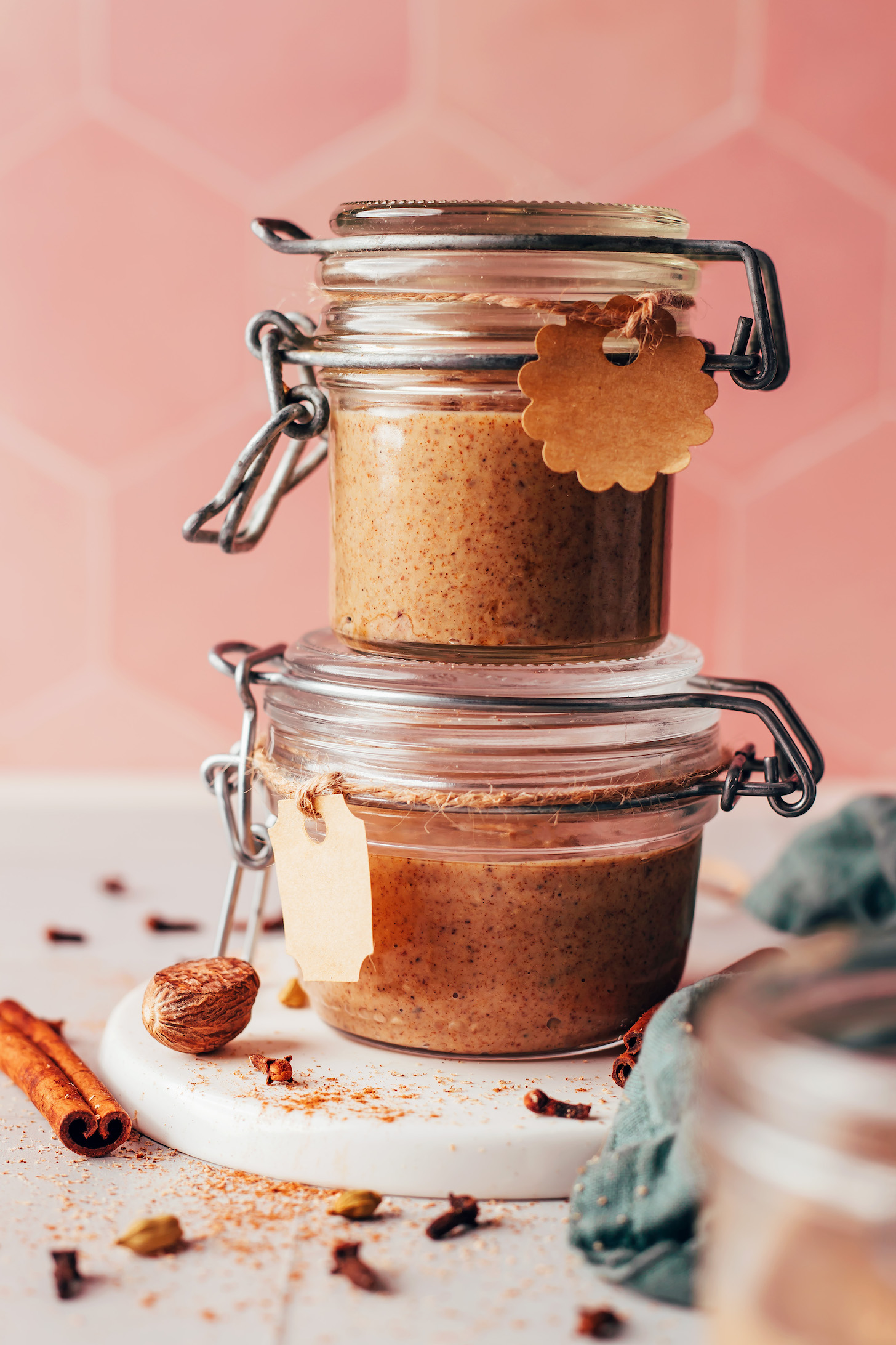 Stack of two glass jars of chai-spiced nut butter with cute tags attached for gifting
