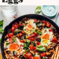Cast iron skillet filled with ratatouille and eggs