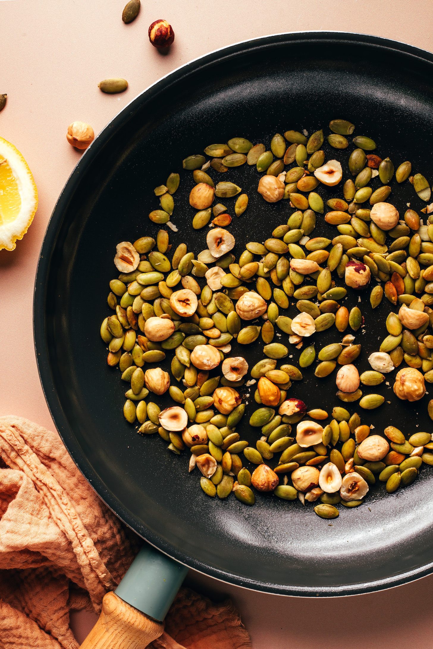 Toasted pepitas and hazelnuts in a skillet