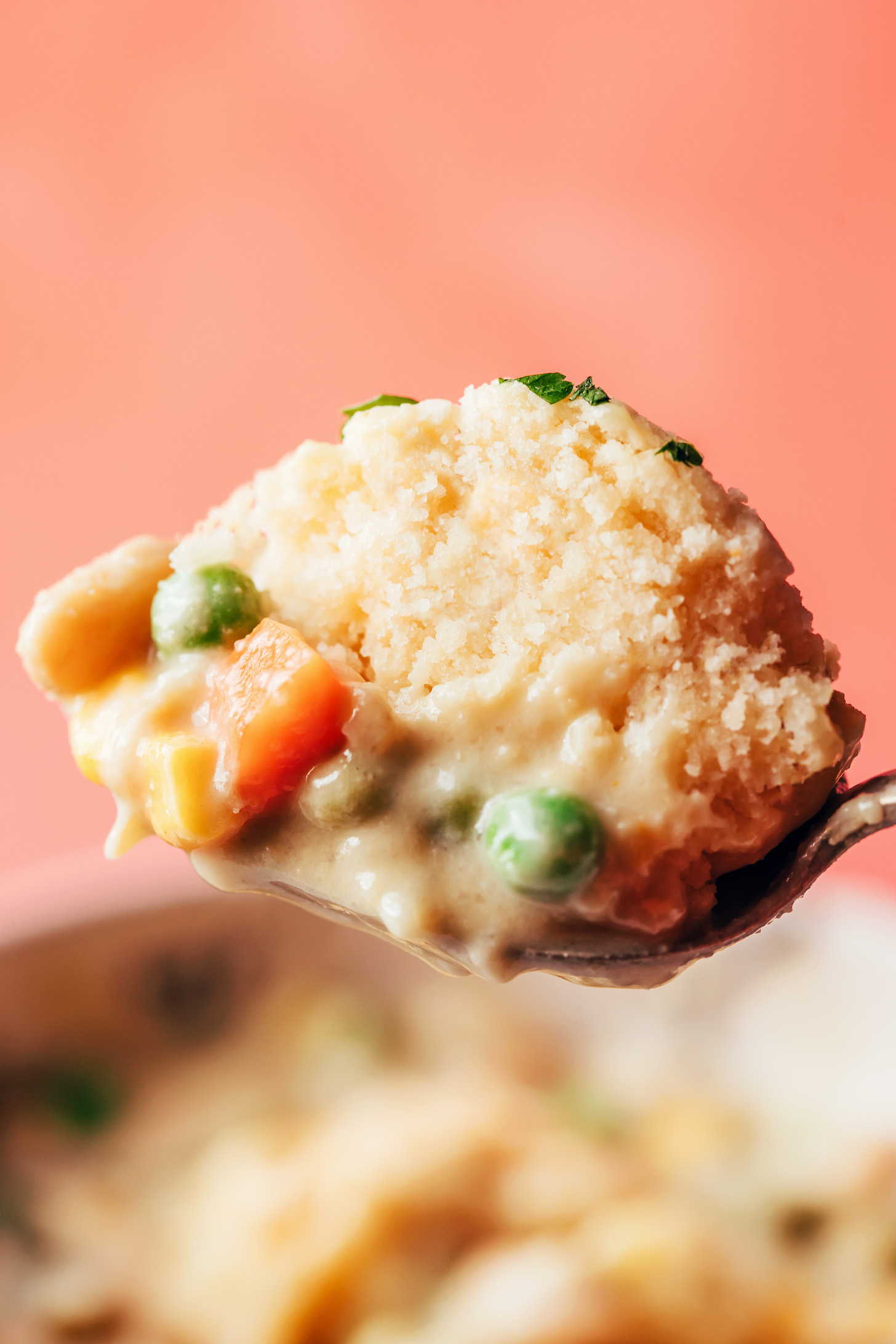 Close up shot of a spoonful with a fluffy vegan gluten-free biscuit over a creamy soup