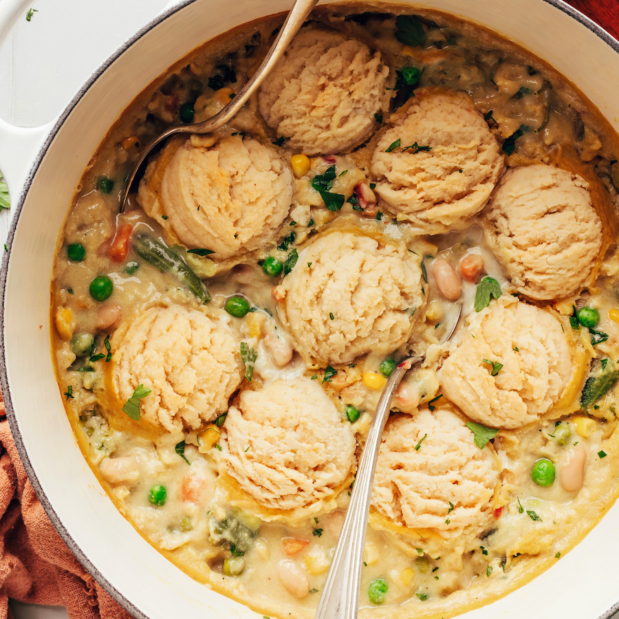 Spoons in a Dutch oven filled with our vegan pot pie soup recipe