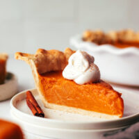 Slice of vegan gluten-free sweet potato pie topped with coconut whipped cream