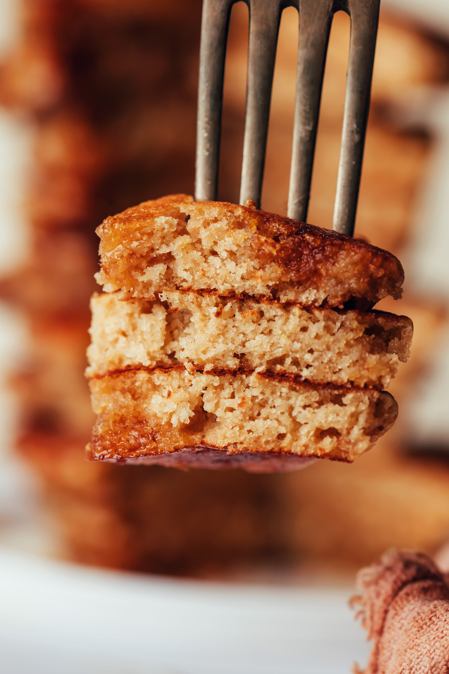 Close up shot of a bite of fluffy gluten-free pancakes on a fork