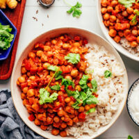 Vegan vindaloo-inspired chickpea curry in bowls with rice and cilantro