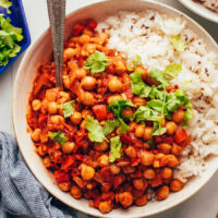 Overhead shot of a bowl of vegan vindaloo chickpea curry with rice and cilantro
