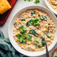 Close up photo of a bowl of creamy vegan white bean chili topped with cilantro