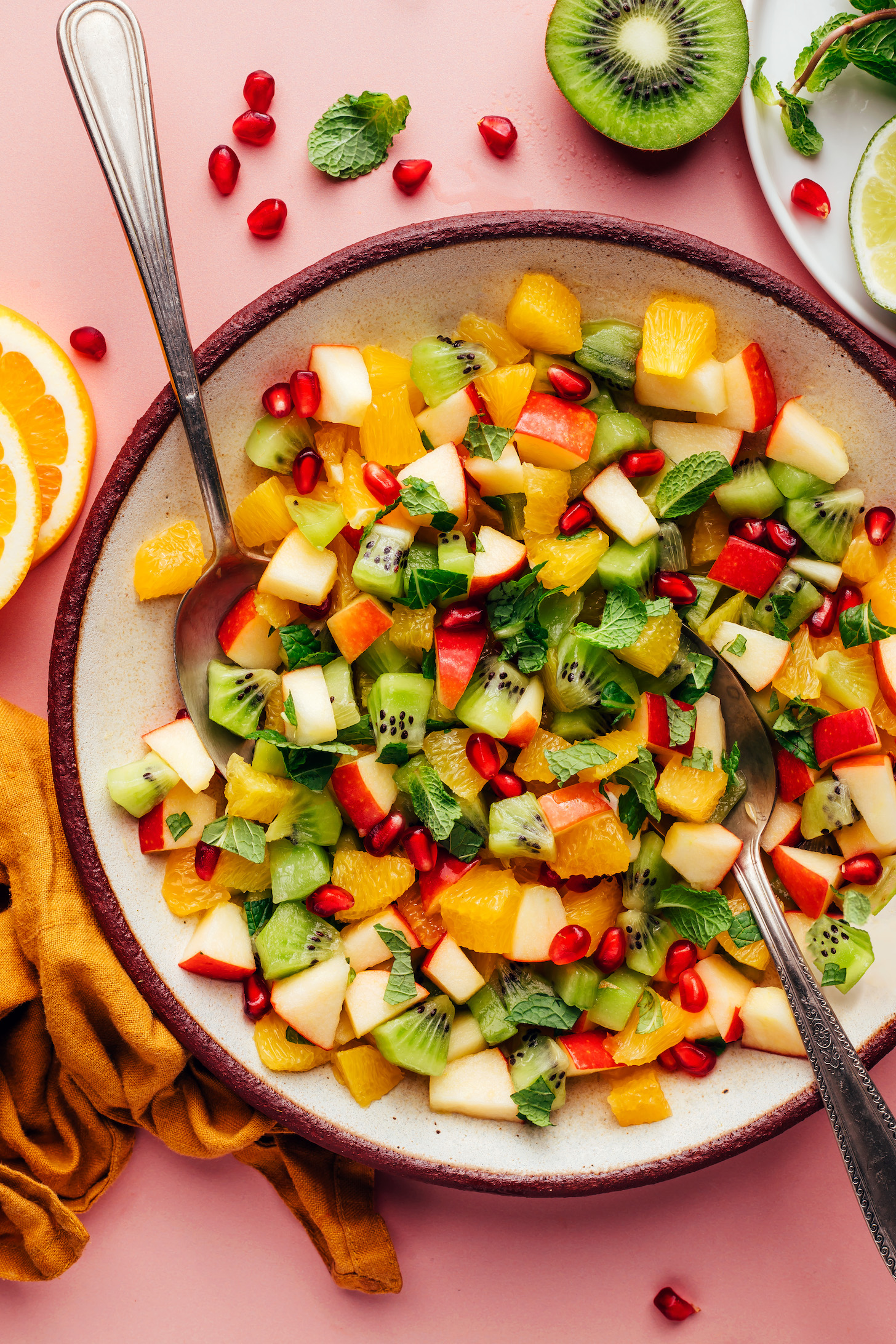 Serving spoons resting in a bowl of our easy winter fruit salad recipe